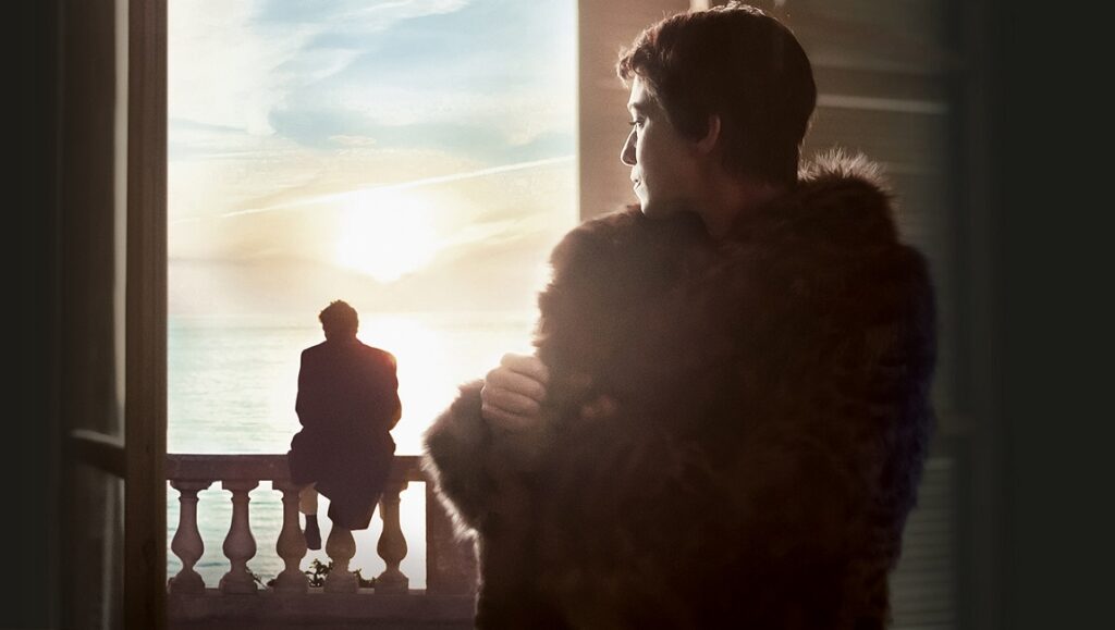 Suzanna Andler | Benoît Jacquot Suzanna Andler film still. Woman in fur coat looks out at man on balcony overlooking the sea at sunset.