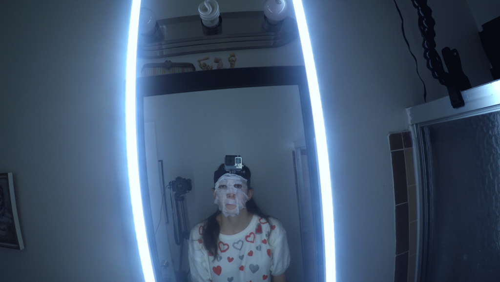 Mirror selfie of a woman wearing a face mask and a GoPro camera. The Mimic, Sator, Cowboys.