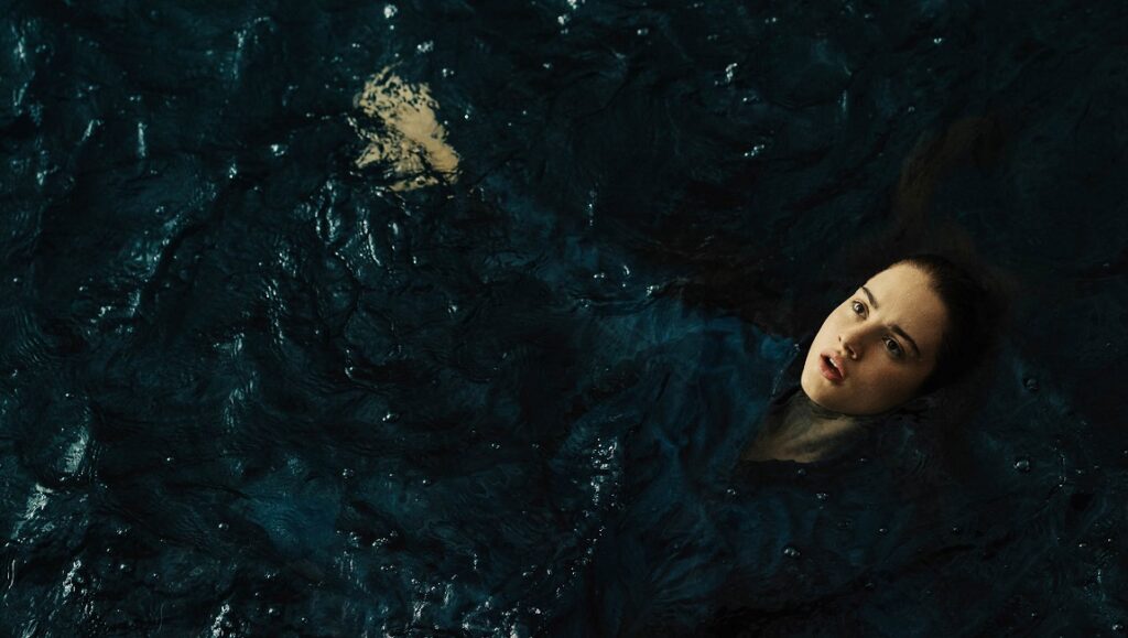 Still from Mayday at Sundance Film Festival. Woman in dark water looks up, concerned.