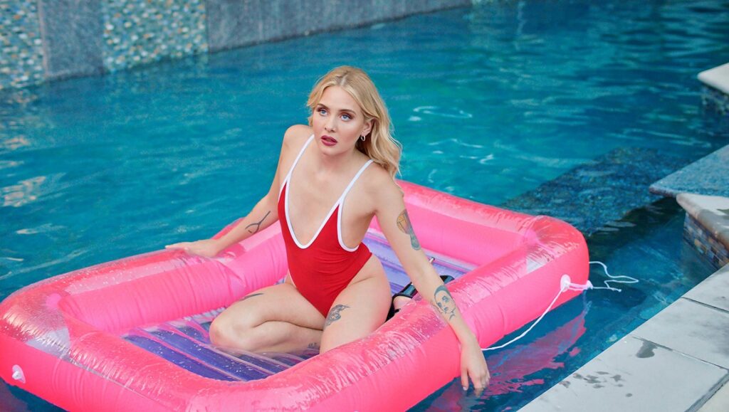 Pleasure — Ninja Thyberg Pleasure film at Sundance: Woman in red swimsuit on pink raft in pool.