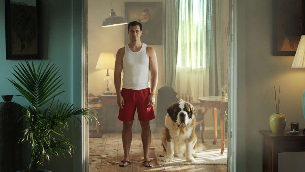 The Mimic movie scene: Man in tank top with St. Bernard dog in living room.