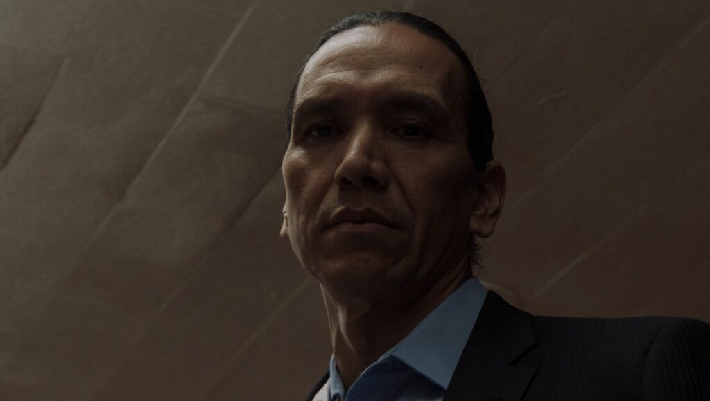 Wild Indian | Lyle Mitchell Corbine Jr. Michael Greyeyes in Wild Indian, Sundance Film Festival 2021 film. Intense close-up portrait.