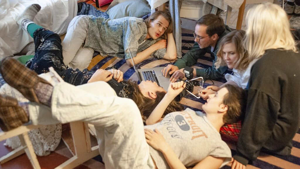 SXSW Film Festival 2021 — Dispatch 4: Fucking with Nobody, Witch Hunt, Jakob’s Wife Group of friends lounging on a rug, using a laptop. Casual, relaxed atmosphere. Friendship goals.