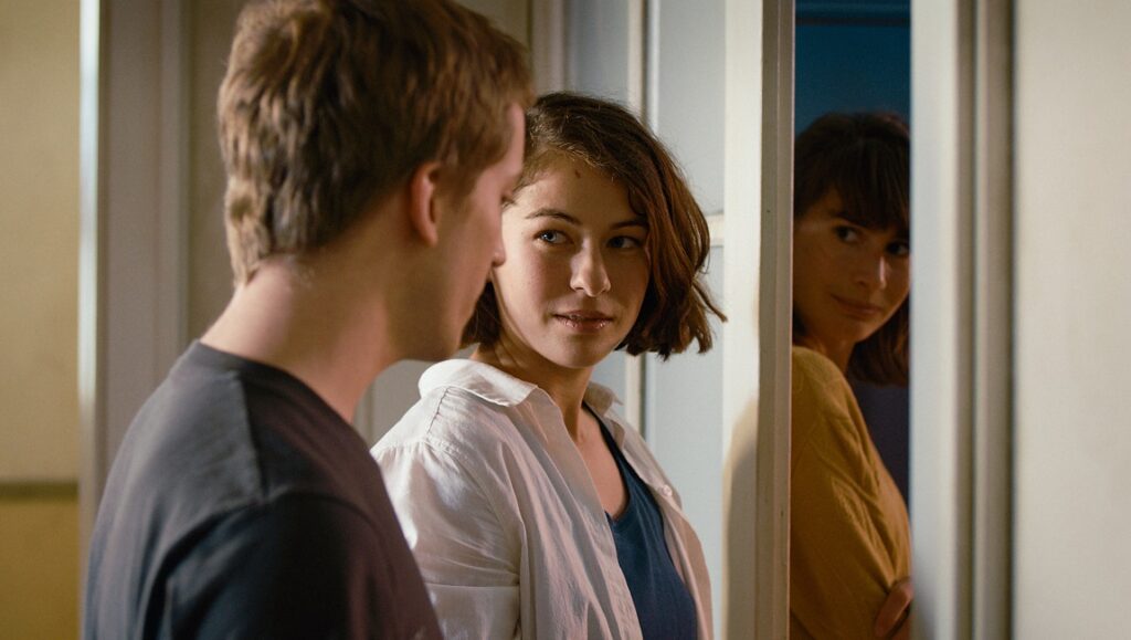 The Girl and the Spider film still. Two women and a man in a doorway. Berlin Film Festival 2021.