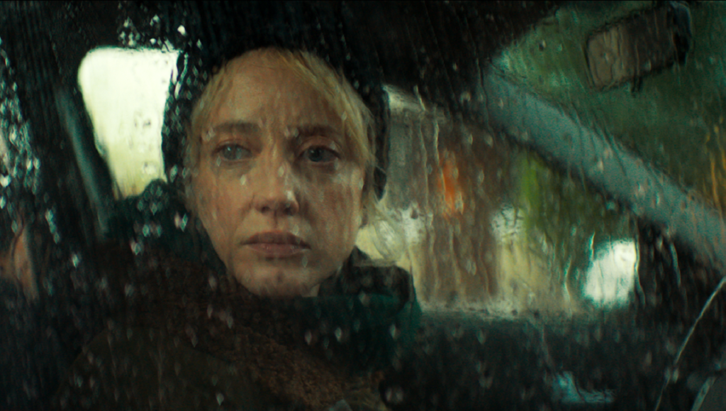 Here Before | Stacey Gregg Andrea Riseborough in Here Before driving in the rain. Psychological thriller film.