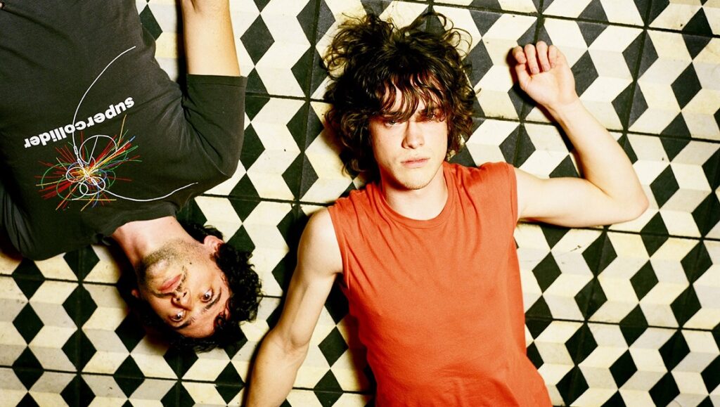 MGMT's Oracular Spectacular album art. Band members lying on a geometric floor.