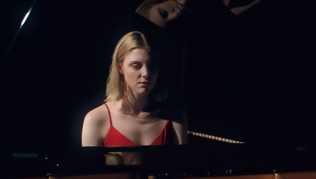 Bloodthirsty movie scene. Woman in red dress at piano, dark mood. Amelia Moses film.