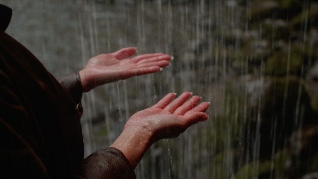 Boys from County Hell film still. Hands catching water, possibly holy water.
