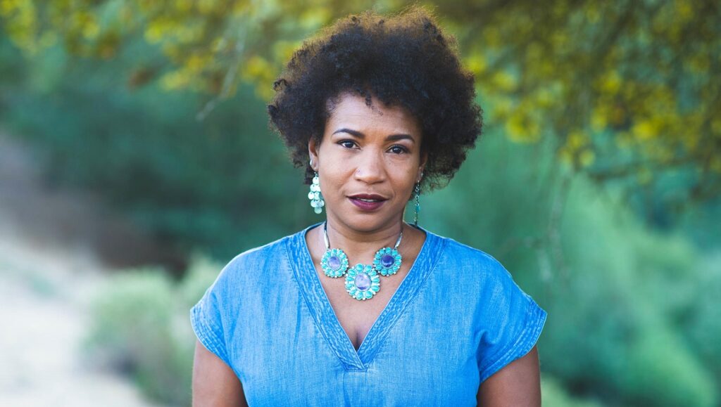 Mikomarks album review. Woman with afro, turquoise jewelry, and blue shirt. March 2021 music roundup.