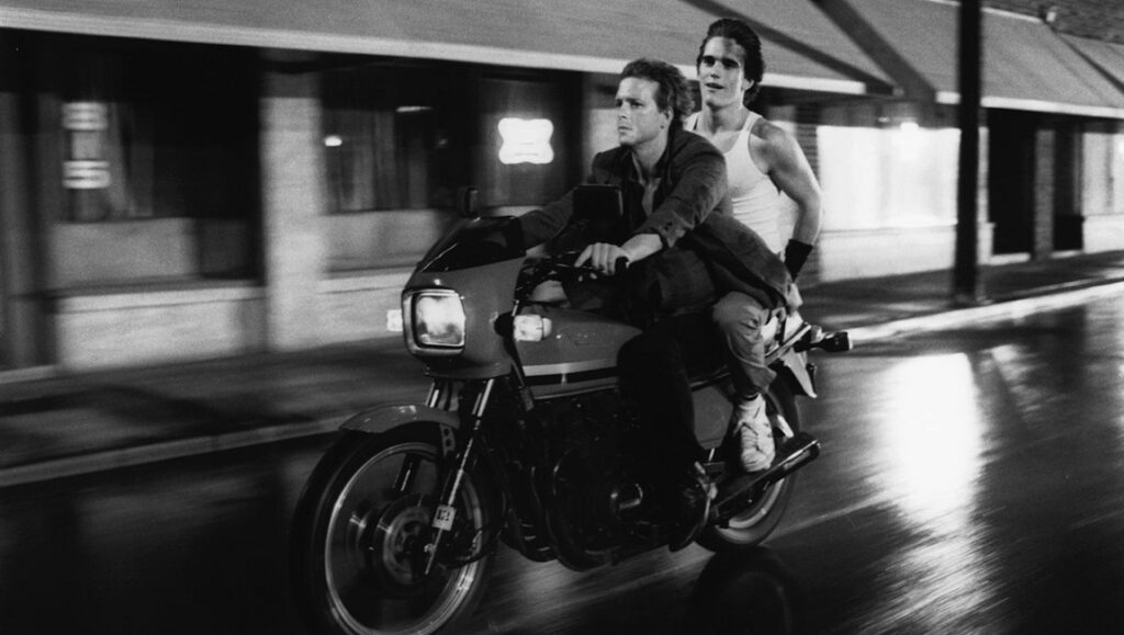 Rumble Fish movie still: Matt Dillon and Mickey Rourke ride a motorcycle. Francis Ford Coppola film.