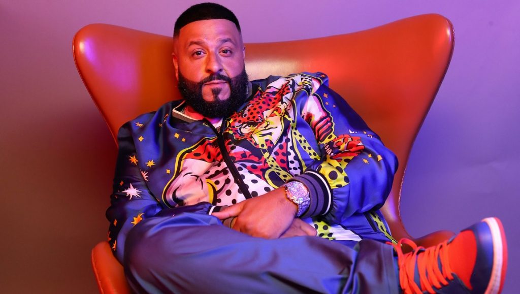 DJ Khaled | KHALED KHALED DJ Khaled sitting in chair. KHALED KHALED album artist with beard wearing colorful jacket and sneakers.