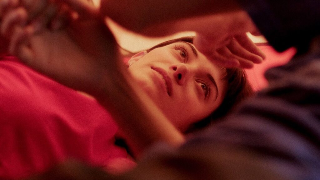 Friends and Strangers film still. Woman lying down, looking up. New Directors/New Films 2021.