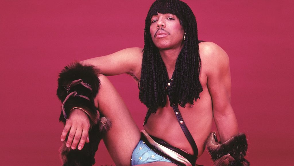 Rick James portrait. Musician with dreadlocks, fur cuffs, and blue studded underwear. 80s fashion icon.