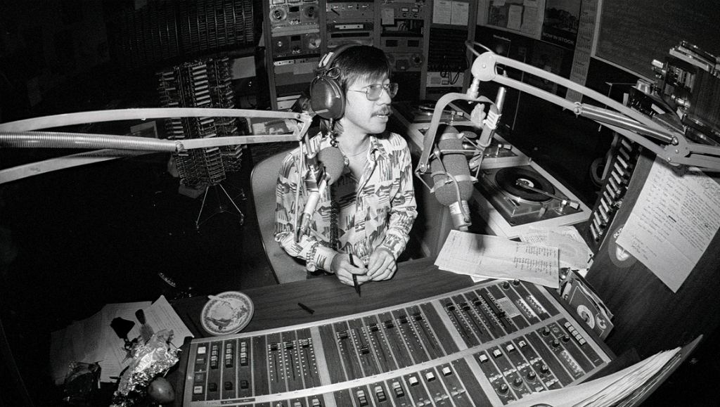 Black and white image of radio DJ in studio for Like a Rolling Stone film at Tribeca Film Festival 2021.