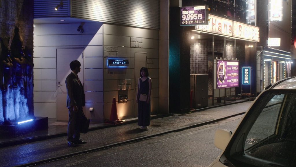 The Real Thing movie scene: Man and woman standing on a street at night in Japan.