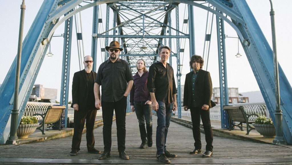 Drive-By Truckers band portrait on a blue bridge, promoting Brighter Than Creation's Dark album.