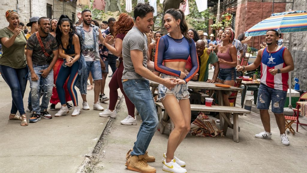 In the Heights | John M. Chu In the Heights movie scene: Couple dancing in the street, surrounded by a joyful crowd. Musical film by John M. Chu.