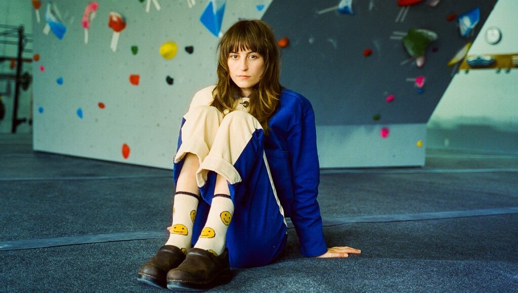 Faye Webster | I Know I’m Funny haha Faye Webster, I Know I’m Funny haha album art. Singer-songwriter in a climbing gym with smiley face socks.