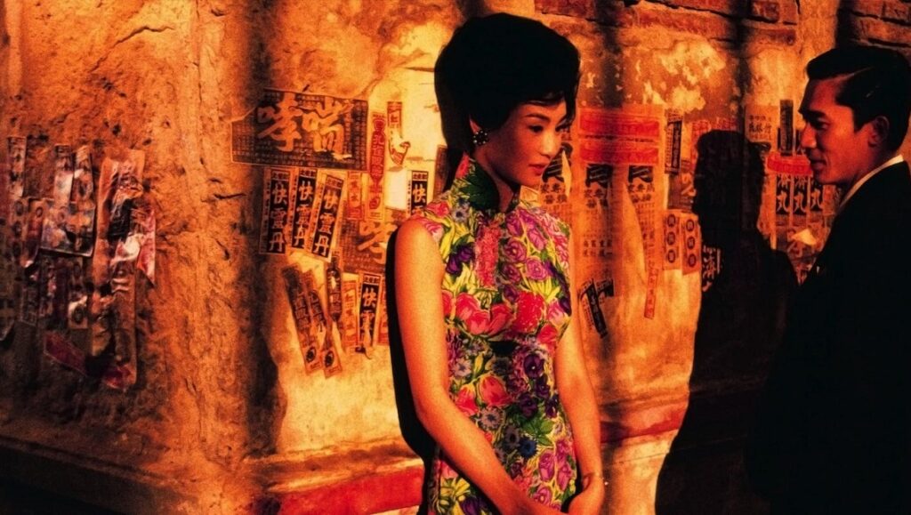 In the Mood for Love — Wong Kar-wai In the Mood for Love film still. Maggie Cheung in floral cheongsam with Tony Leung. Wong Kar-wai movie.