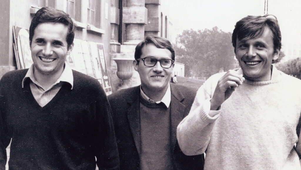 Marx Can Wait — Marco Bellocchio Vintage photo of smiling intellectuals. Three men in casual sweaters and a blazer, outdoors. Black and white portrait.