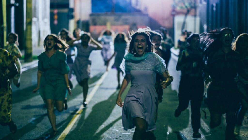 Frightened women run in Medusa movie scene. Thriller film with screaming women fleeing in panic on a dark street.