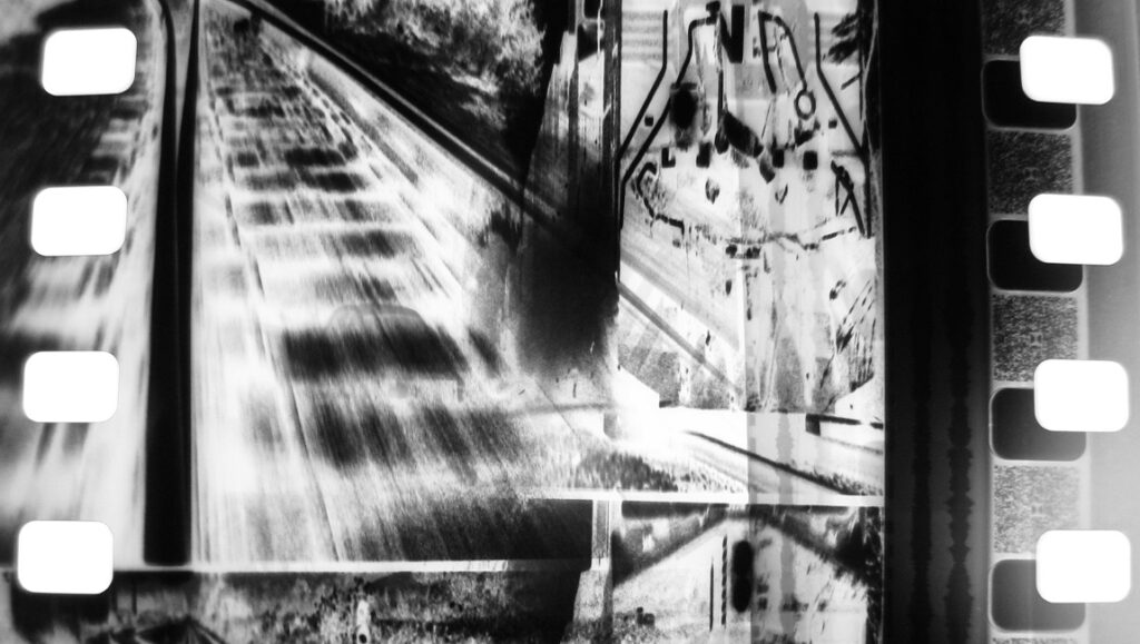 Train Again — Peter Tscherkassky Black and white film still from Peter Tscherkassky's Train Again, featuring railroad tracks.