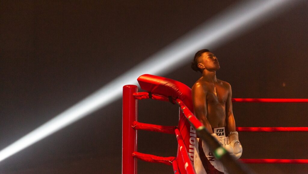 One Second Champion | Chiu Sin-Hang Chiu Sin-Hang, One Second Champion movie still. Boxer in ring, spotlight.