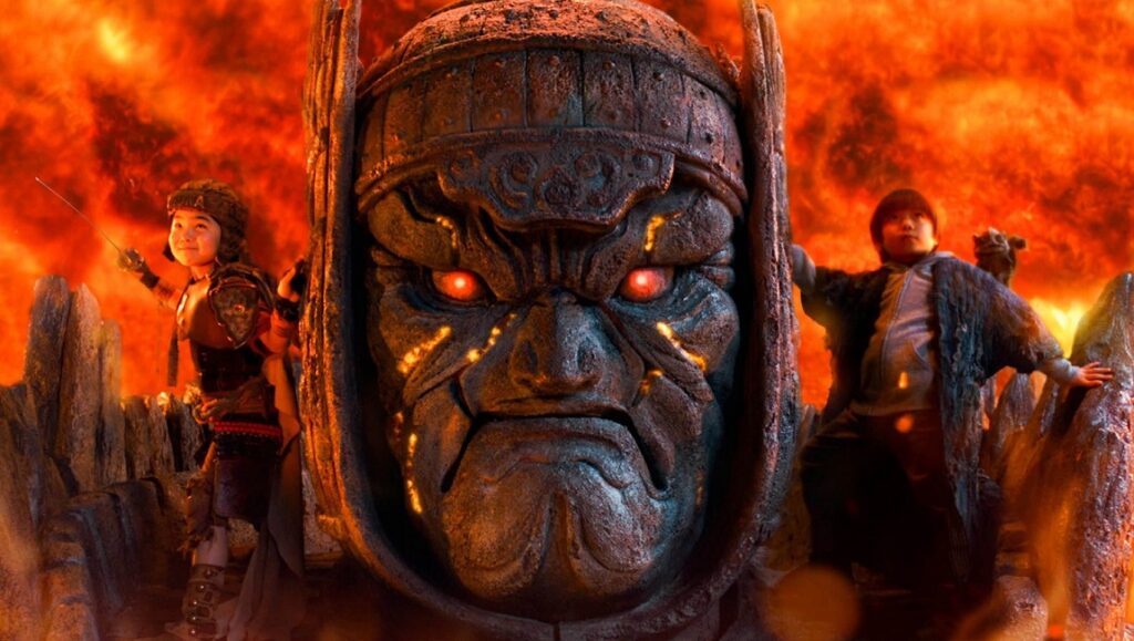 The Great Yokai War: Guardians. Japanese fantasy film scene with giant stone guardian and two children.