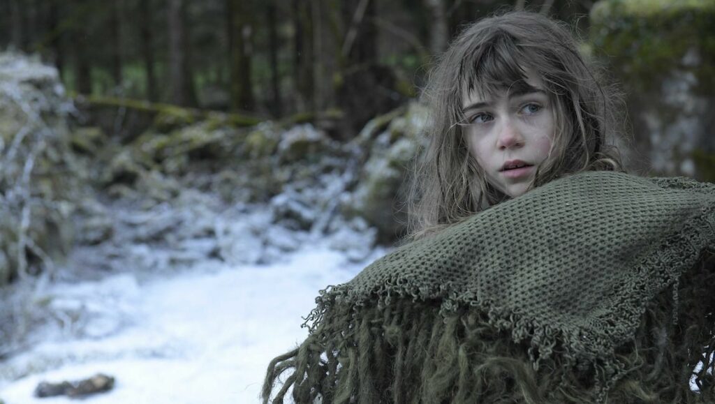 All the Moons movie still. Girl with a shawl in a snowy forest. Fantasy film scene.