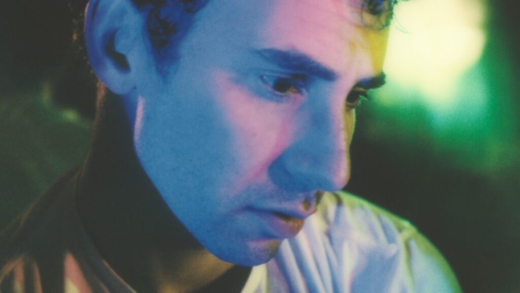 Bleachers | Take the Sadness Out of Saturday Night Bleachers album review, July 2021. Close up of a man with blue and pink lighting. New music.