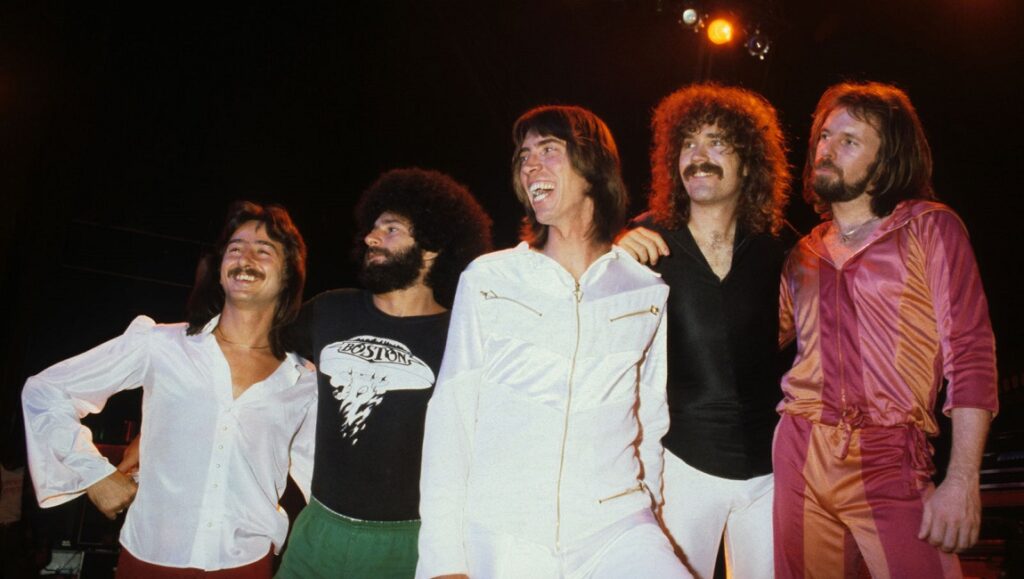 Band Boston onstage. Group shot of rock musicians in 1970s fashion.