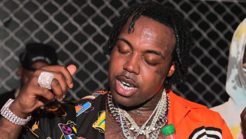 EST Gee | Bigger Than Life or Death EST Gee, July 2021 album roundup. Rapper with iced-out jewelry and colorful shirt. New music review.