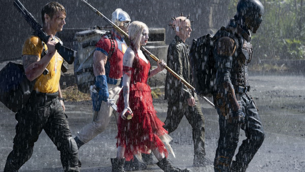 The Suicide Squad cast in the rain. Margot Robbie as Harley Quinn in red dress. James Gunn film.