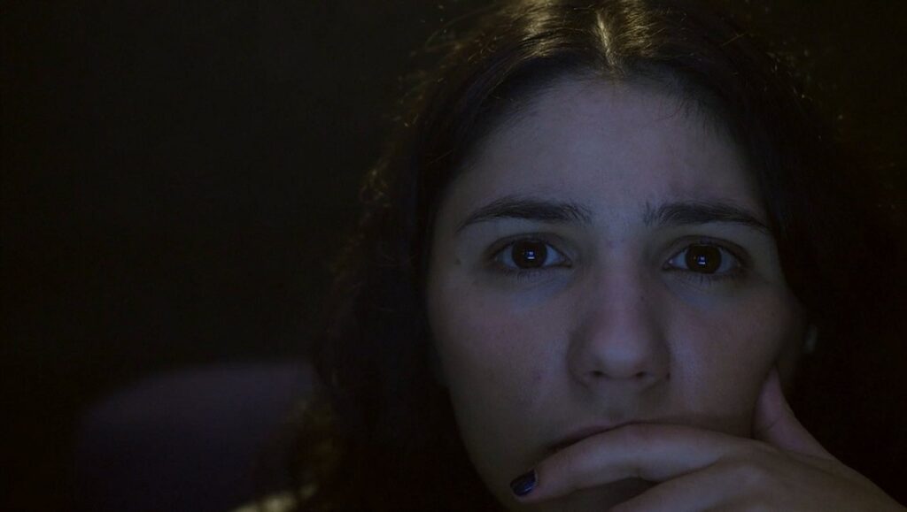 The Viewing Booth | Ra’anan Alexandrowicz Close-up of a woman watching The Viewing Booth film. Concerned expression, hand to mouth. Ra’anan Alexandrowicz documentary.