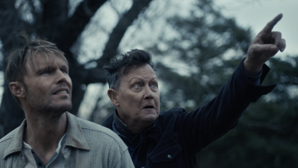 What Josiah Saw movie still. Two men look up, one pointing. Suspenseful, dramatic.