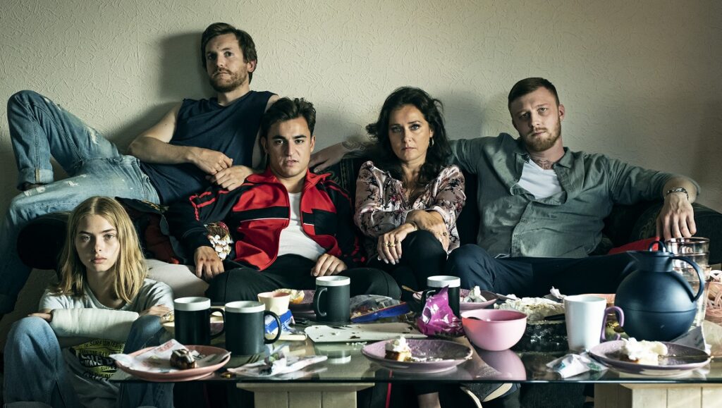 Wildland | Jeanette Nordahl Wildland movie image: Jeanette Nordahl film cast on a sofa with a messy table. Drama, crime, family.