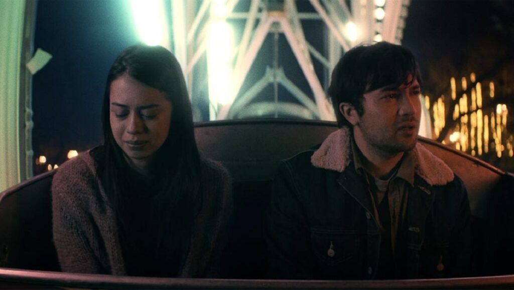 The Wheel — Steve Pink TIFF 2021 film still from *The Wheel*: Couple on a Ferris wheel at night.