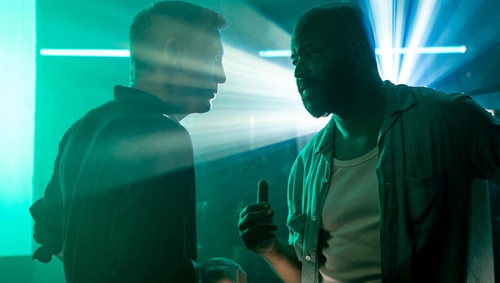 No Time to Die movie scene. Two men face each other in a tense confrontation. Cary Joji Fukunaga film.