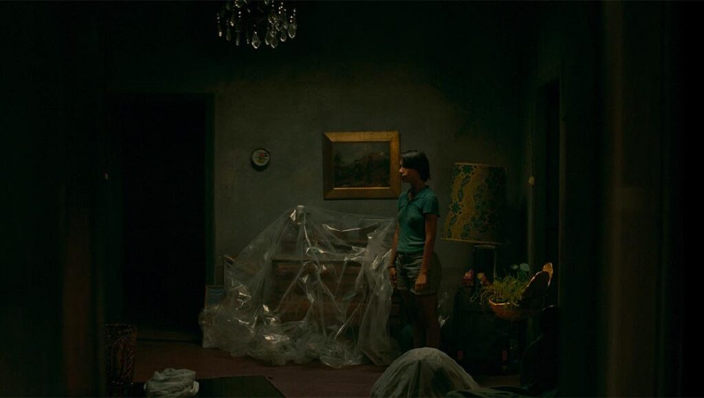To Kill the Beast film still. Woman in a dimly lit, covered room. Agustina San Martín movie scene.