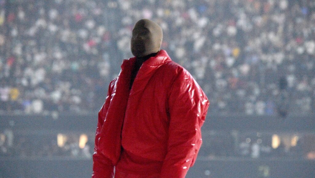 Album Roundup — August 2021 | Part 3: Kanye West, Big Red Machine, Deafheaven Kanye West at August 2021 album event. Red jacket, mask, and crowd.