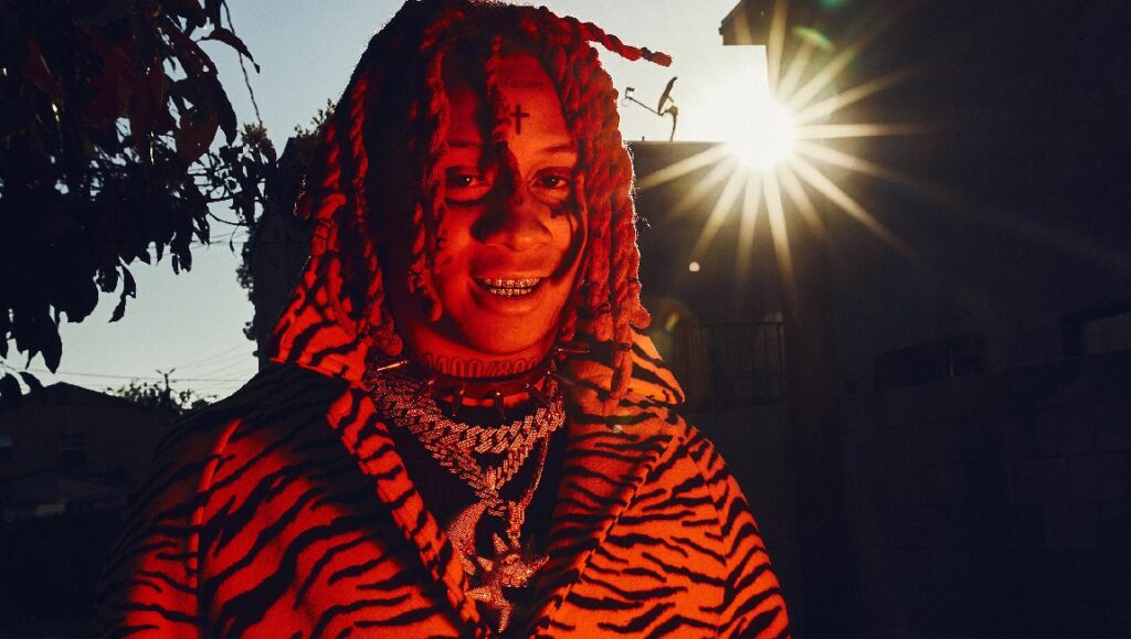 Trippie Redd | Trip at Knight Trippie Redd, August 2021 album. Rapper with red dreads, tiger-striped coat, and diamond chains.