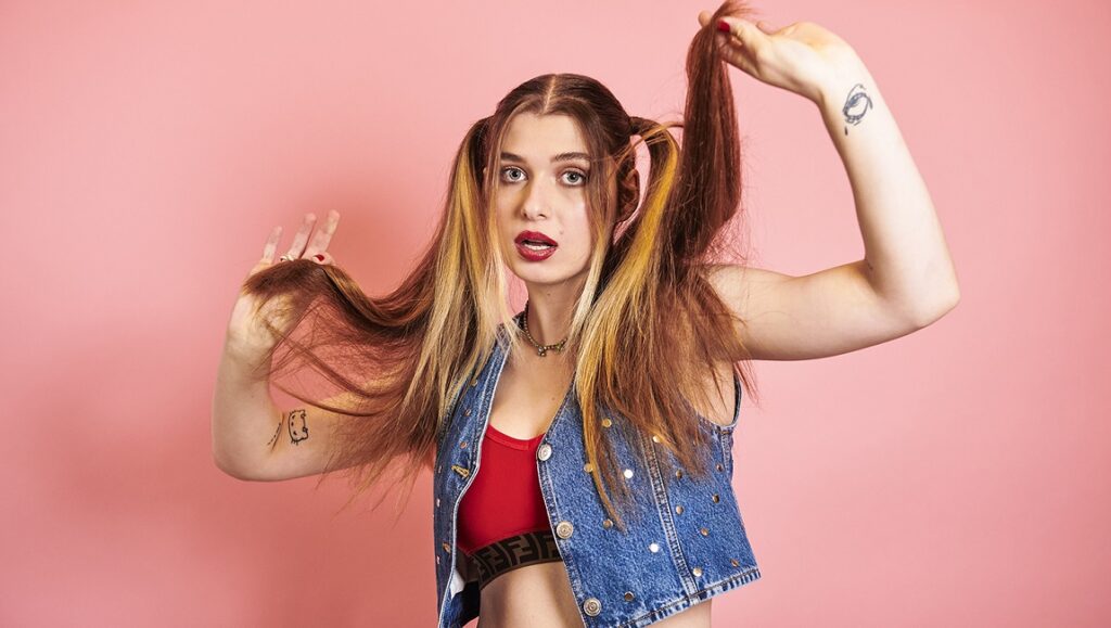 Baby Queen | The Yearbook Baby Queen, September 2021 album roundup. Woman with pigtails, denim vest, and tattoos. Pop music artist.