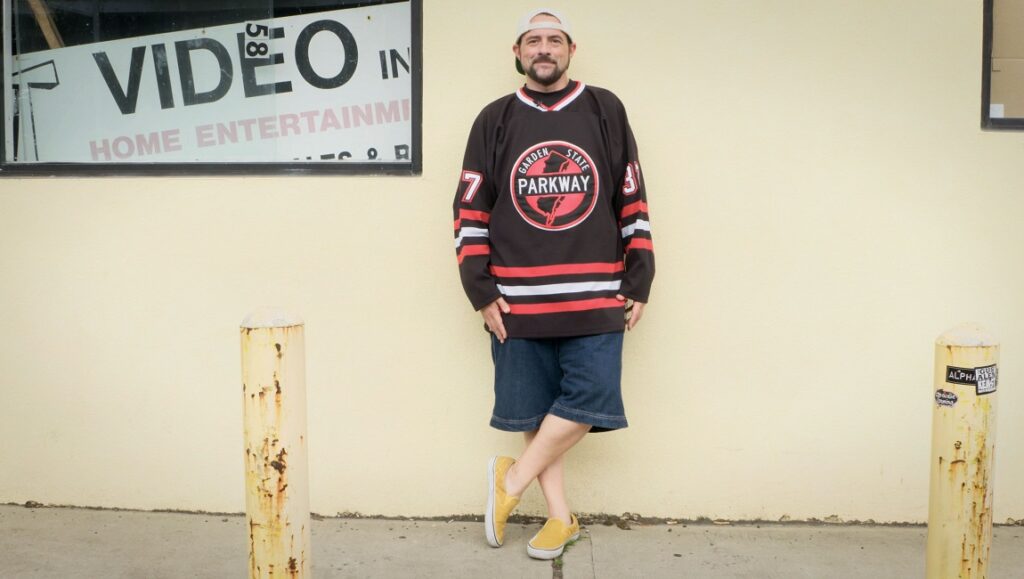 Clerk | Malcolm Ingram Clerks movie reference. Man in hockey jersey outside video store. Kevin Smith inspired. Indie film vibe.