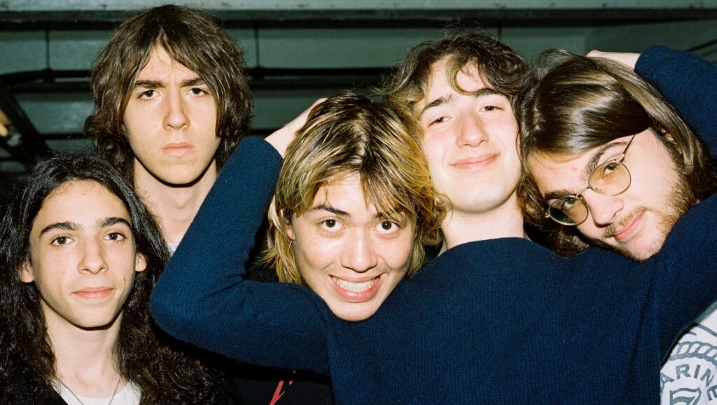 Geese | Projector Portrait of the indie rock band Geese, five young men with varying hairstyles, posing closely together.