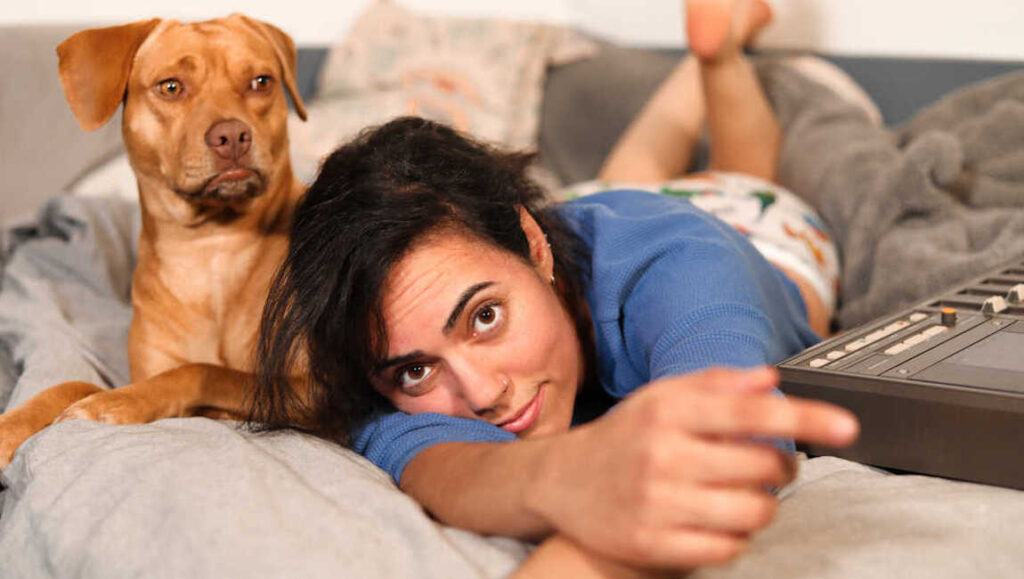 Illuminati Hotties | Let Me Do One More Illuminati Hotties album review: Sarah Tudzin with her dog on a bed. October 2021 music roundup.