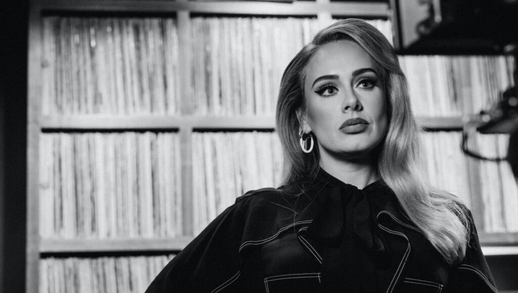 Adele | 30 Black and white portrait of Adele, November 2021 album roundup. Singer with hoop earrings and record collection.