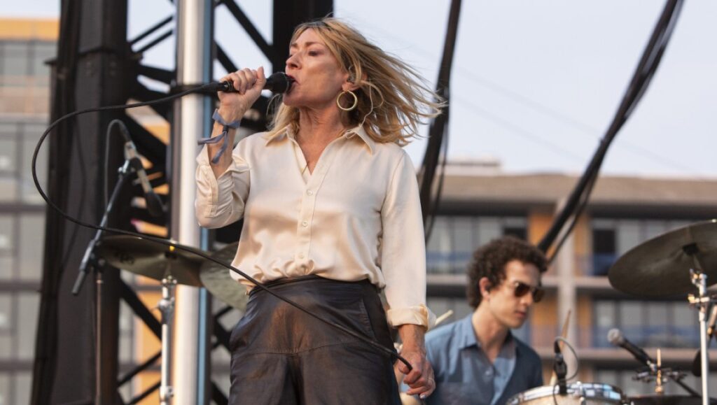 Kim Gordon performs live in November 2021. Singer on stage with microphone and drummer. Album Roundup.