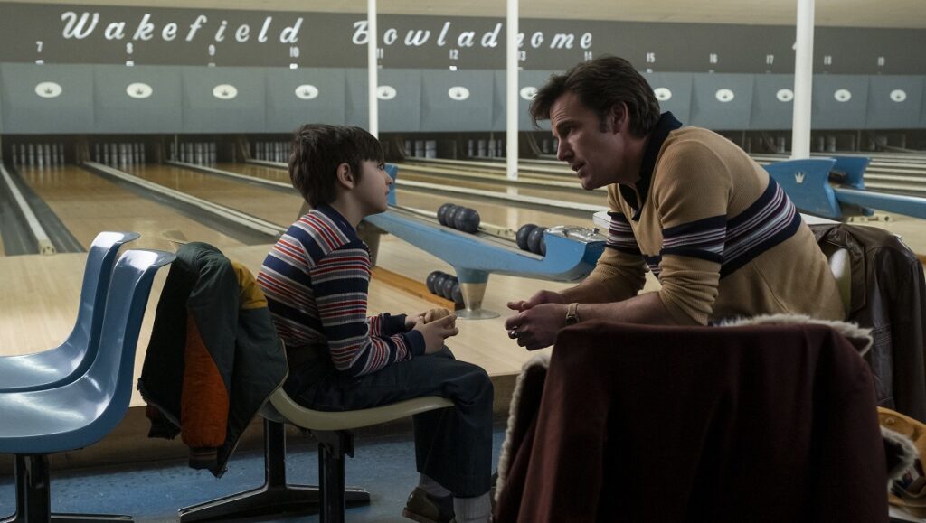 The Tender Bar movie scene. George Clooney with a young boy at a bowling alley. Film still.