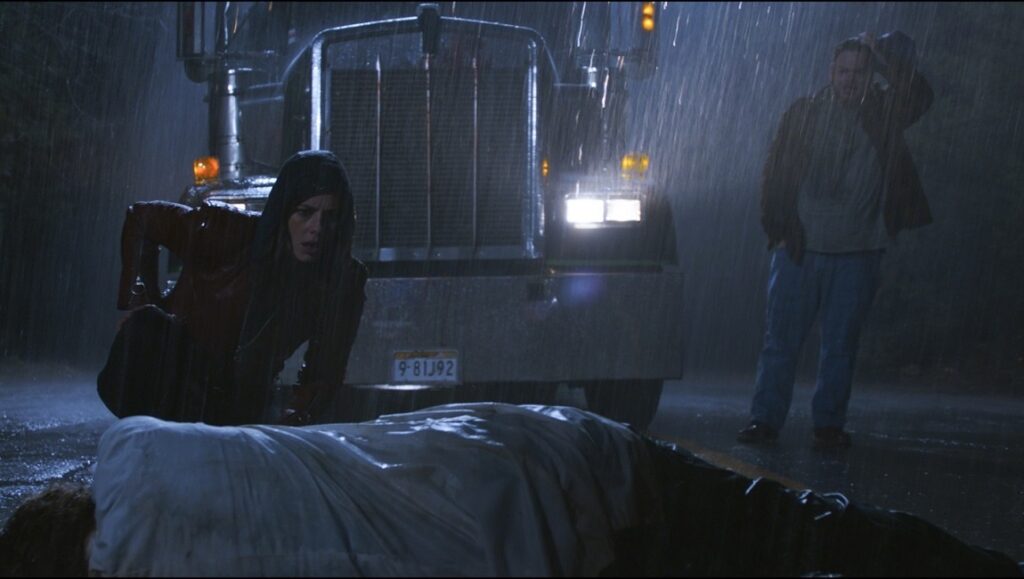 Resident Evil: Welcome to Raccoon City | Johannes Robert Resident Evil: Welcome to Raccoon City scene. Woman by body, truck in rain.