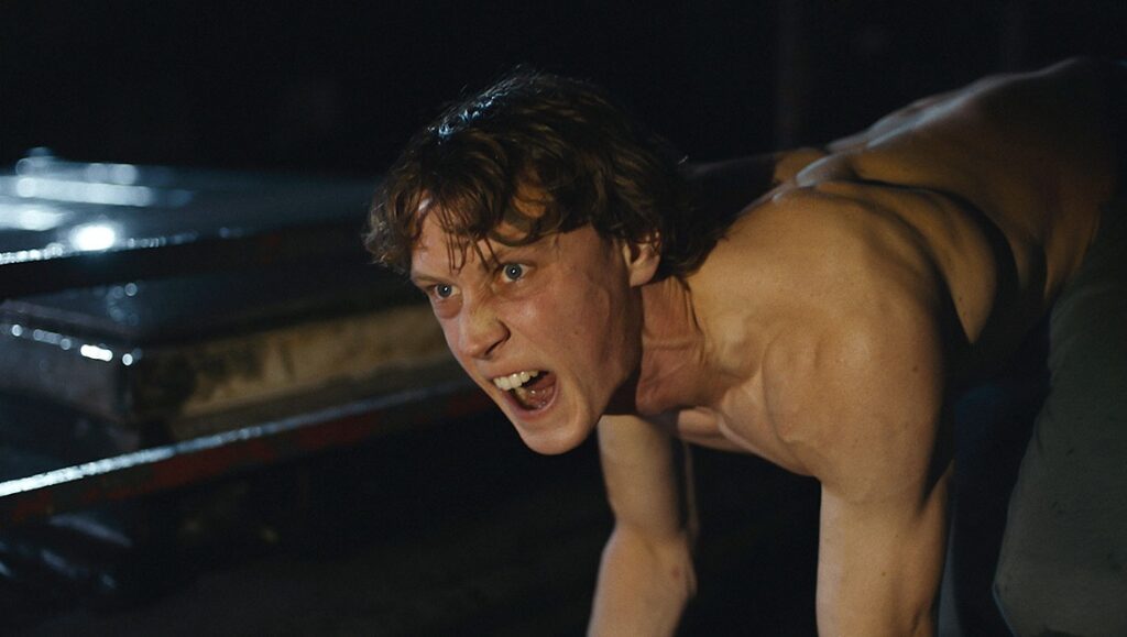 Wolf movie still. Man with bare torso, snarling. Nathalie Biancheri film.